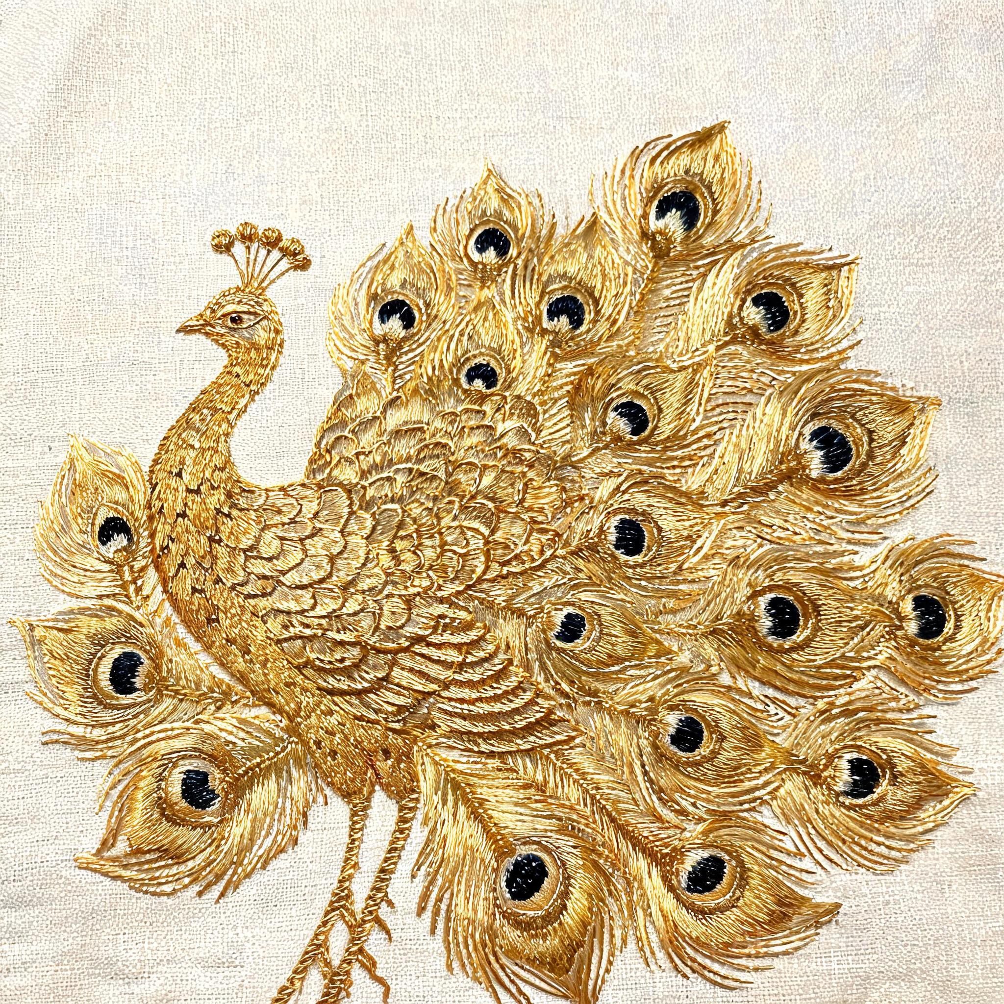 Close-up of golden silk peacock embroidery showing intricate feather eye detail and metallic thread gradation