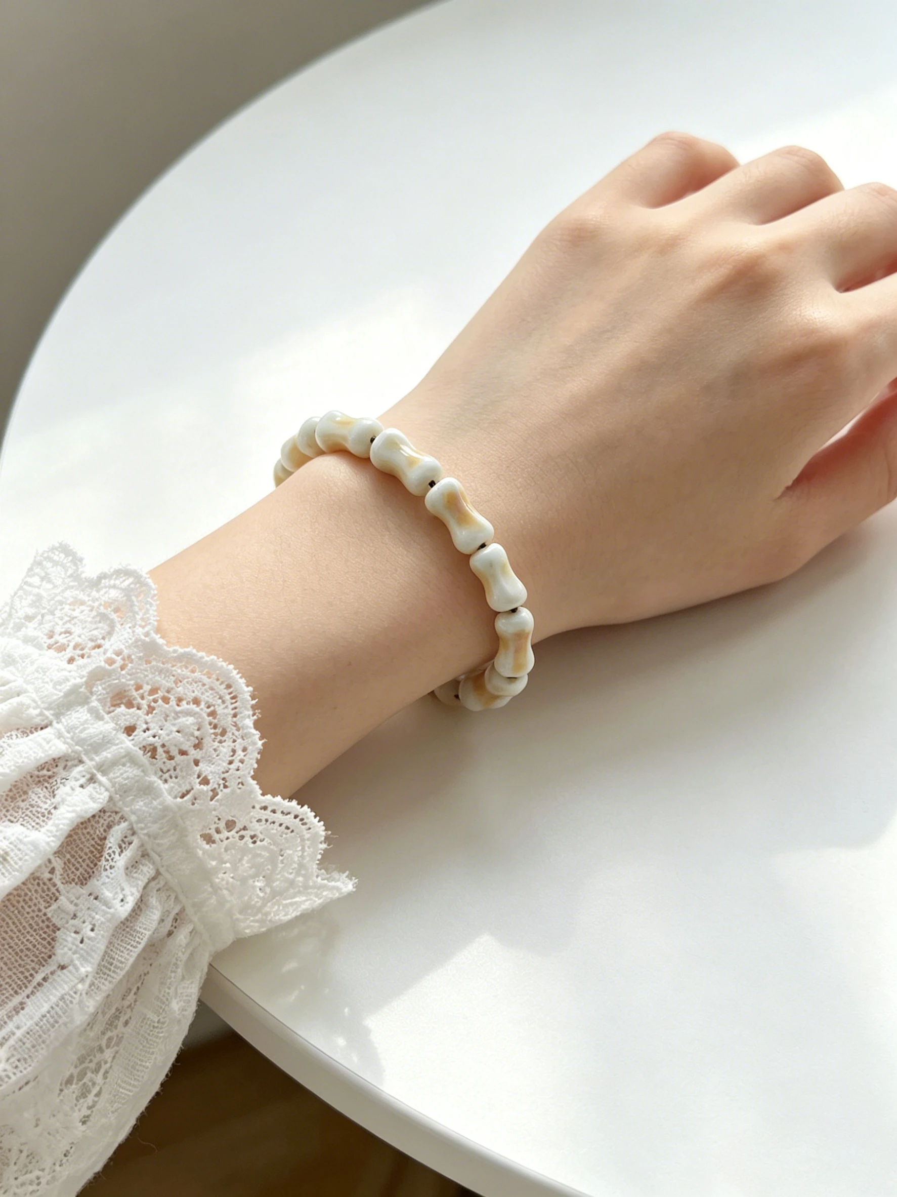 Handmade ceramic beaded bracelet with iridescent pearl glaze on open book (3).png